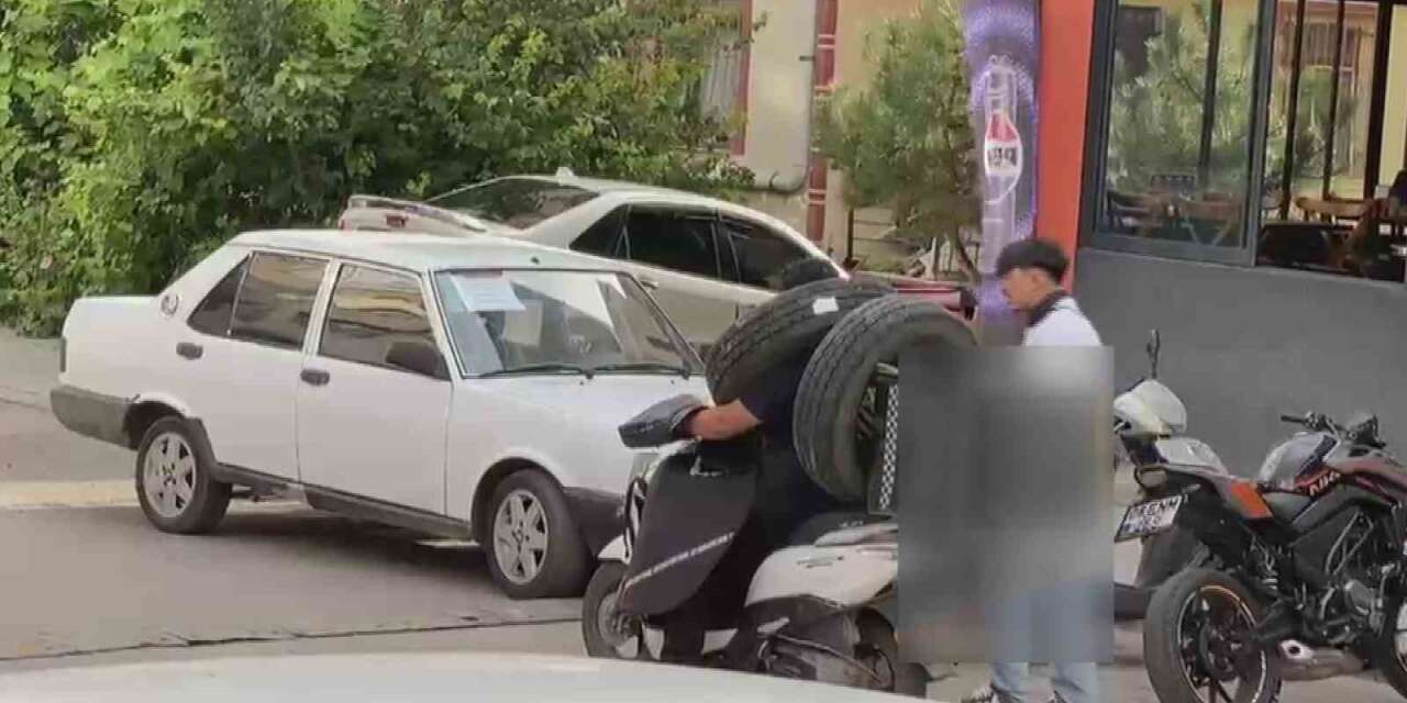 otomobil-lastigini-boynuna-asan-kuryenin-ilginc-tasima-yontemi-kameraya-yansidi